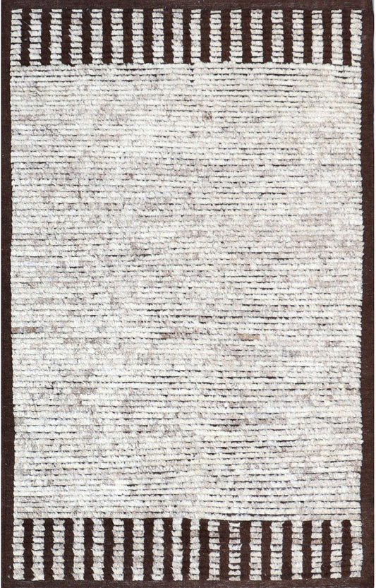 A square area rug with a textured, heathered off-white and light gray center field, framed by a dark brown border with vertical tufted stripes at the top and bottom.Atlantica Organics curates antique and handmade rugs, Persian, Afghan, Tibetan, Pakistani, Turkish Oushak, Kilim, Khotan, tribal and contemporary textiles for luxury interiors, homes and real estate. Our collections connect timeless craftsmanship with interior design, furniture, fine art, architecture and modern living. Explore curated rugs, col