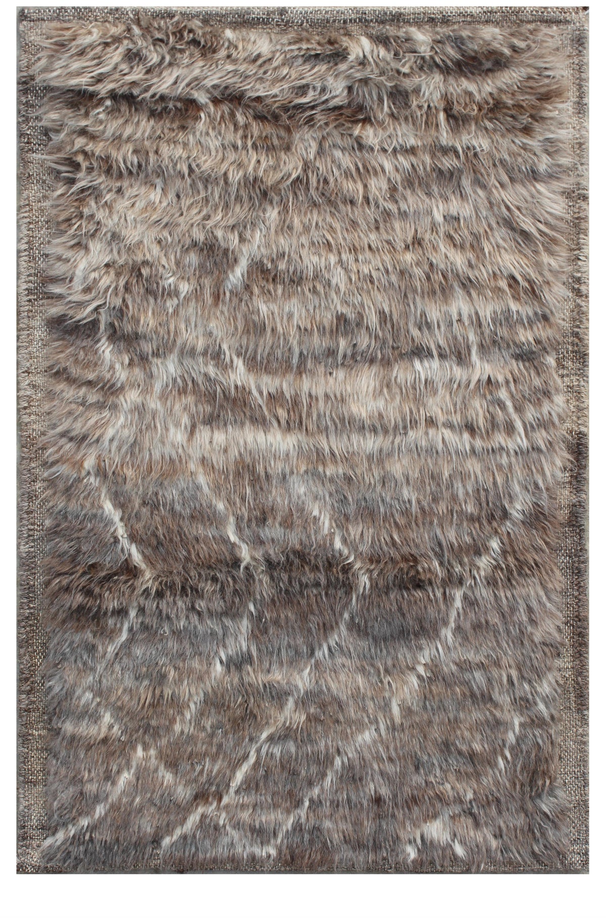 A rectangular shag area rug with a textured, faux-fur-like surface in a mottled blend of brown, gray, beige, and off-white tones, featuring a subtle diagonal geometric pattern. Atlantica Organics curates antique and handmade rugs, Persian, Afghan, Tibetan, Pakistani, Turkish Oushak, Kilim, Khotan, tribal and contemporary textiles for luxury interiors, homes and real estate. Our collections connect timeless craftsmanship with interior design, furniture, fine art, architecture and modern living. Explore curat