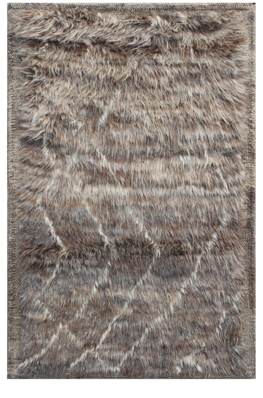 A rectangular shag area rug with a textured, faux-fur-like surface in a mottled blend of brown, gray, beige, and off-white tones, featuring a subtle diagonal geometric pattern. Atlantica Organics curates antique and handmade rugs, Persian, Afghan, Tibetan, Pakistani, Turkish Oushak, Kilim, Khotan, tribal and contemporary textiles for luxury interiors, homes and real estate. Our collections connect timeless craftsmanship with interior design, furniture, fine art, architecture and modern living. Explore curat