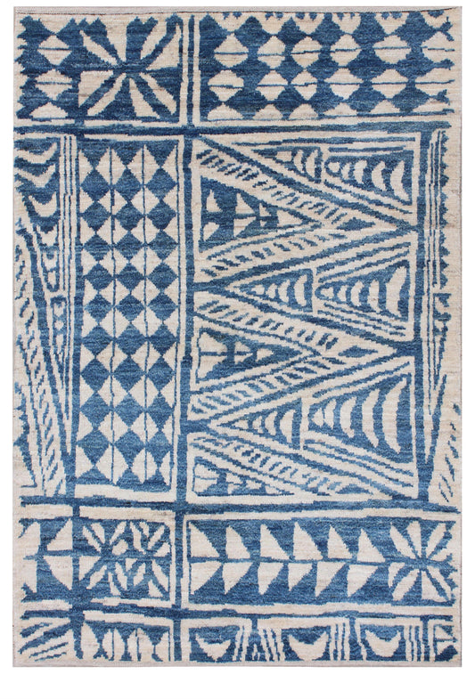 A square area rug with a bold geometric tribal pattern in medium blue and off-white, featuring blocks of diamonds, triangles, and stripes. Atlantica Organics curates antique and handmade rugs, Persian, Afghan, Tibetan, Pakistani, Turkish Oushak, Kilim, Khotan, tribal and contemporary textiles for luxury interiors, homes and real estate. Our collections connect timeless craftsmanship with interior design, furniture, fine art, architecture and modern living. Explore curated rugs, collectible textiles, natural