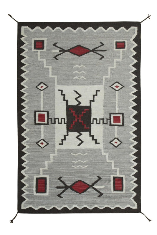 A rectangular woven rug with a Southwestern geometric pattern, featuring a light gray field, a black zigzag border, and red and white accents. Atlantica Organics curates antique and handmade rugs, Persian, Afghan, Tibetan, Pakistani, Turkish Oushak, Kilim, Khotan, tribal and contemporary textiles for luxury interiors, homes and real estate. Our collections connect timeless craftsmanship with interior design, furniture, fine art, architecture and modern living. Explore curated rugs, collectible textiles, nat