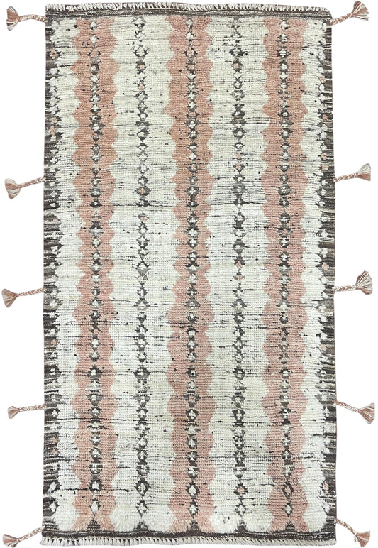 A rectangular woven rug with a distressed vertical stripe pattern in dusty pink, cream, and charcoal gray, finished with tassel ties on the sides.Atlantica Organics curates antique and handmade rugs, Persian, Afghan, Tibetan, Pakistani, Turkish Oushak, Kilim, Khotan, tribal and contemporary textiles for luxury interiors, homes and real estate. Our collections connect timeless craftsmanship with interior design, furniture, fine art, architecture and modern living. Explore curated rugs, collectible textiles, 