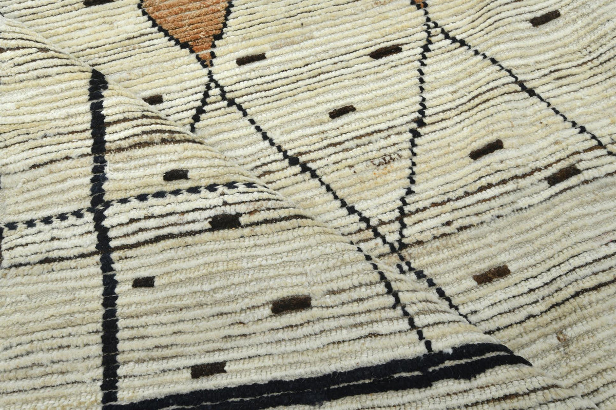 Close-up of a woven textile or rug showing a cream and beige striped pattern with black geometric lines and small brown accents. Atlantica Organics curates antique and handmade rugs, Persian, Afghan, Tibetan, Pakistani, Turkish Oushak, Kilim, Khotan, tribal and contemporary textiles for luxury interiors, homes and real estate. Our collections connect timeless craftsmanship with interior design, furniture, fine art, architecture and modern living. Explore curated rugs, collectible textiles, natural materials