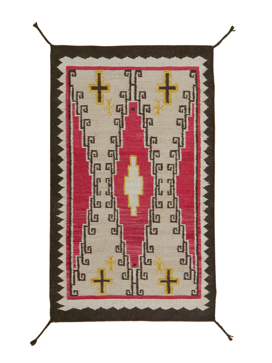 A rectangular woven rug with a Southwestern geometric pattern, featuring a dark brown border, a central pink field, cream-colored motifs, and yellow accents, shown flat against a white background.Atlantica Organics curates antique and handmade rugs, Persian, Afghan, Tibetan, Pakistani, Turkish Oushak, Kilim, Khotan, tribal and contemporary textiles for luxury interiors, homes and real estate. Our collections connect timeless craftsmanship with interior design, furniture, fine art, architecture and modern li