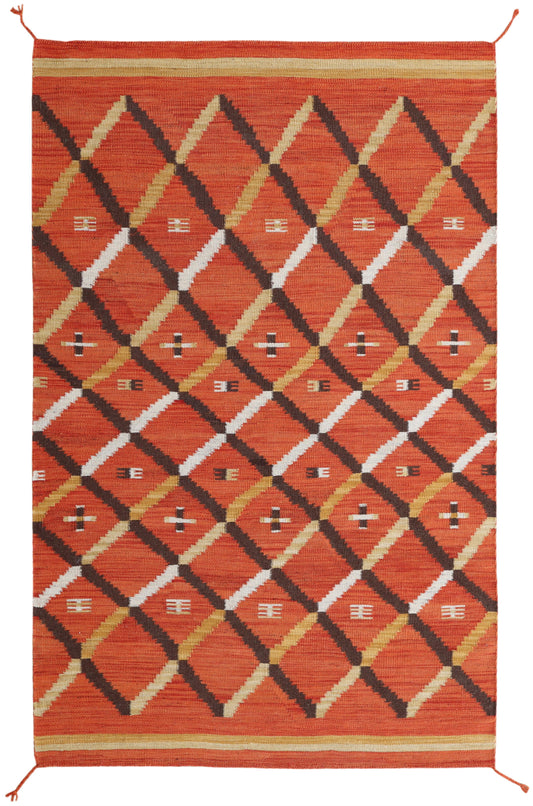 A square woven area rug with a bold geometric diamond pattern in rust orange, black, white, and tan, finished with a matching orange border and small corner ties.Atlantica Organics curates antique and handmade rugs, Persian, Afghan, Tibetan, Pakistani, Turkish Oushak, Kilim, Khotan, tribal and contemporary textiles for luxury interiors, homes and real estate. Our collections connect timeless craftsmanship with interior design, furniture, fine art, architecture and modern living. Explore curated rugs, collec