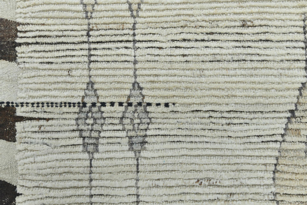 Close-up of a textured woven rug with horizontal ribbed stripes in cream, beige, and gray, featuring vertical geometric diamond patterns. Atlantica Organics curates antique and handmade rugs, Persian, Afghan, Tibetan, Pakistani, Turkish Oushak, Kilim, Khotan, tribal and contemporary textiles for luxury interiors, homes and real estate. Our collections connect timeless craftsmanship with interior design, furniture, fine art, architecture and modern living. Explore curated rugs, collectible textiles, natural 