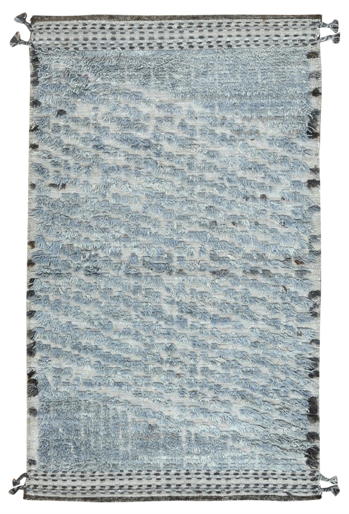 A rectangular woven area rug with a textured, abstract pattern in shades of light blue, gray, and white, featuring dark gray decorative borders and tassels on the top and bottom edges. Atlantica Organics curates antique and handmade rugs, Persian, Afghan, Tibetan, Pakistani, Turkish Oushak, Kilim, Khotan, tribal and contemporary textiles for luxury interiors, homes and real estate. Our collections connect timeless craftsmanship with interior design, furniture, fine art, architecture and modern living. Explo
