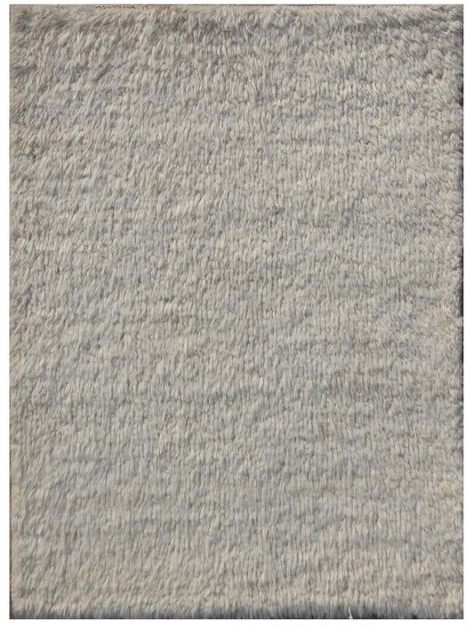 A close-up texture shot of a shaggy, high-pile area rug in a light gray color with subtle heathered variations.Atlantica Organics curates antique and handmade rugs, Persian, Afghan, Tibetan, Pakistani, Turkish Oushak, Kilim, Khotan, tribal and contemporary textiles for luxury interiors, homes and real estate. Our collections connect timeless craftsmanship with interior design, furniture, fine art, architecture and modern living. Explore curated rugs, collectible textiles, natural materials, cultural heritag