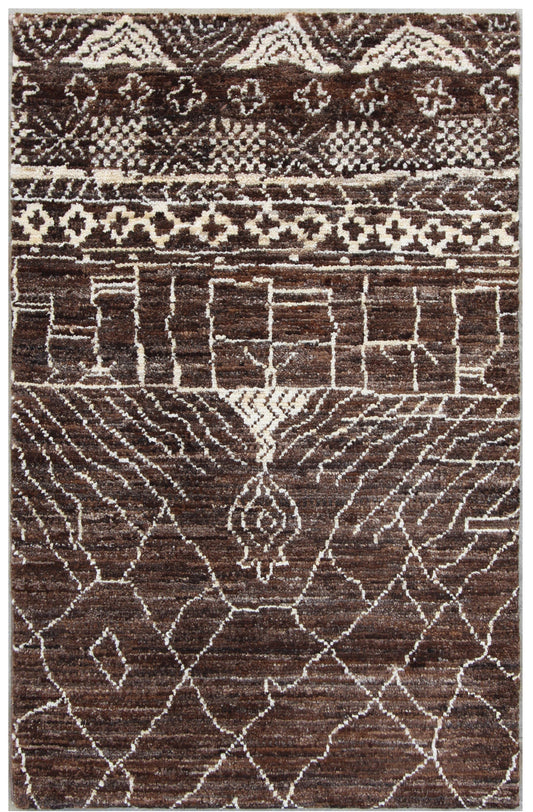 A rectangular area rug with a complex geometric tribal pattern in dark brown, beige, and cream, filling the entire frame.